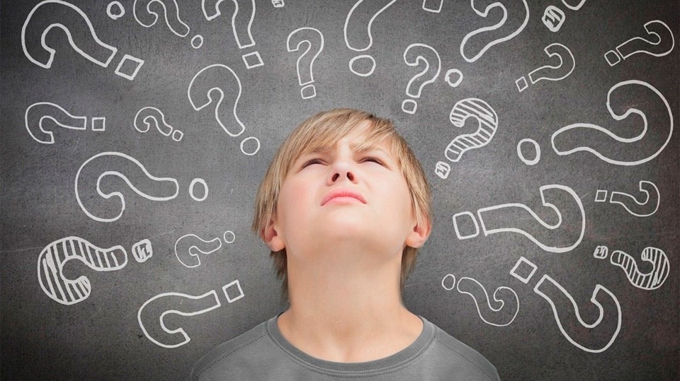 Человек с черным лицом и шеей, стоящий перед доской с текстом.